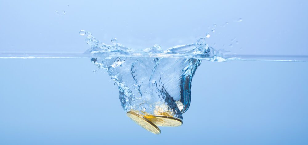 Golden coins falling in water with splashes.