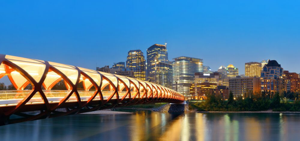 Calgary cityscape with Peace Bridge and downtown skyscrapers in Alberta at night, Canada.