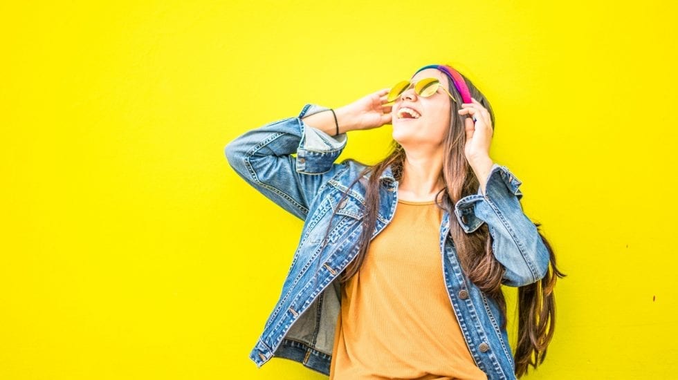 Chica feliz con fondo amarillo.