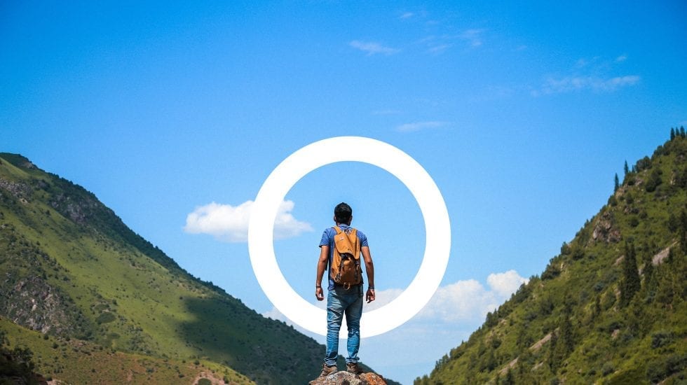 Un chico en la cima de una montaña, listo para su próximo reto, con ayuda y subvenciones de Aming