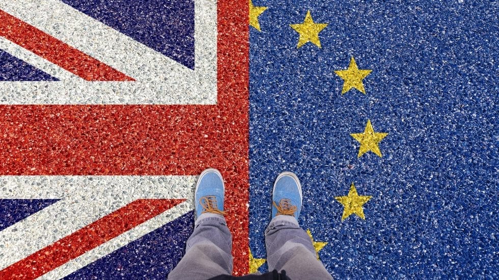 Consecuencias de un Brexit duro, unos pies pisan una alfombra en la que la mitad es la bandera de UK y la otra mitad la de la UE.