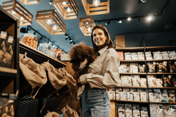 woman in pet store holding a small dog